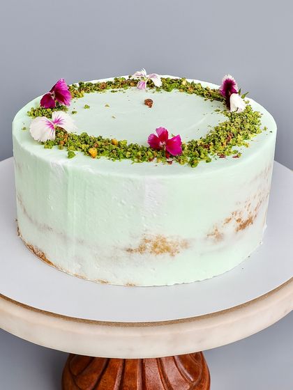 This Pistachio White Chocolate Naked Cake is all about delicate flavor and satisfying texture. The soft pistachio sponge is layered with a silky pistachio white chocolate ganache and a sprinkle of nougatine for a delightful crunch.