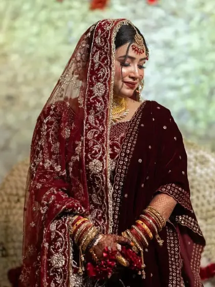 A full-length portrait of a bride in her stunningly detailed wedding lehenga, capturing her elegance and poise.