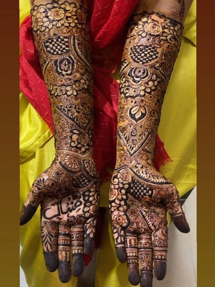A stunning bridal henna design with checkerboard patterns and floral motifs.