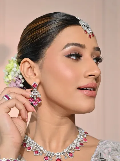 A classic beauty pose, showcasing the elegant lines of the makeup and the stunning jewelry. The look is polished, sophisticated, and utterly modern.