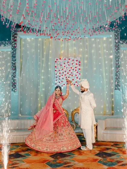 A grand stage shot of the couple after their varmala, with sparklers adding to the celebration.