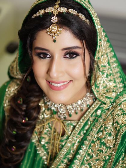 Radiance in green for the stunning Sunaina. This look embraces tradition with a touch of modern elegance, featuring a soft smokey eye and a flawless complexion that enhances her bridal glow.