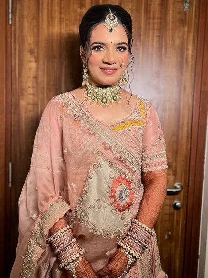 The complete look, showcasing the pastel lehenga, the intricate jewellery, and the elegant hair updo.
