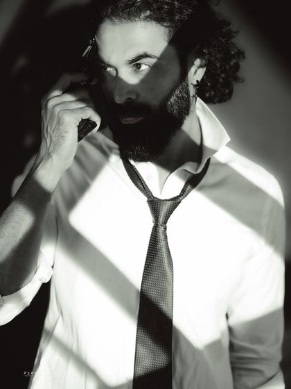 An intense and dramatic close-up. The use of shadow and the prop create a compelling narrative, like a still from a classic thriller film.