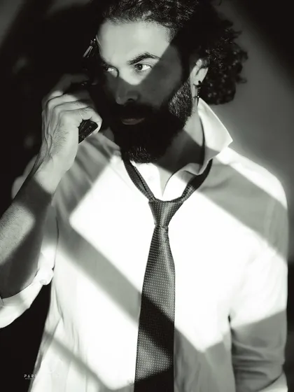 An intense and dramatic close-up. The use of shadow and the prop create a compelling narrative, like a still from a classic thriller film.