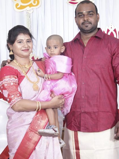 A family portrait at a traditional function. The mother's makeup is subtle and refined, suitable for a daytime event with family.