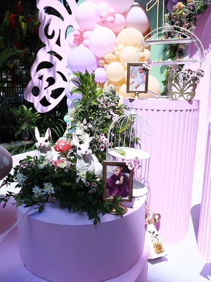 I love it when clients share cute photos to include in the decor. These little framed pictures, nestled among whimsical rabbit props and florals, add a deeply personal and heartwarming touch to the celebration.