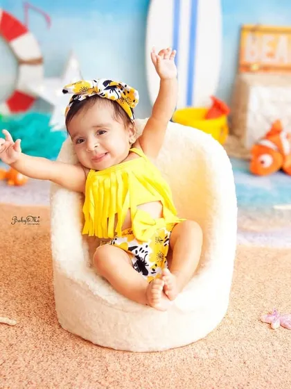A big, happy wave from the beach. Her joyful energy is contagious. These are the moments that make for unforgettable first birthday pictures.