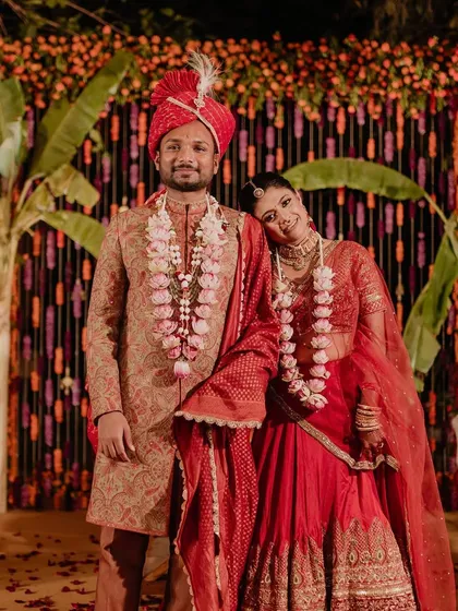 Embracing tradition with a modern flair. This couple wanted a vibrant, colorful wedding, so we designed a stunning backdrop using thousands of orange and red marigolds, complemented by banana leaf pillars for a rich, festive look.