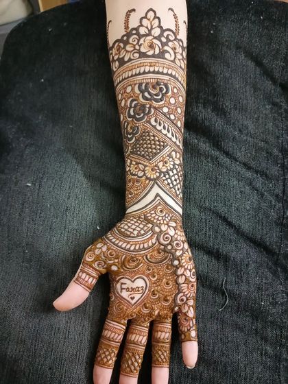A romantic touch for this bride, with her partner's name, 'Faraz', written inside a heart on her palm.