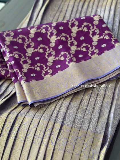 A luxurious combination of a pleated silver-gold tissue skirt and a purple brocade dupatta.