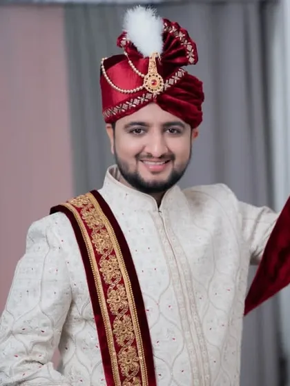 The groom looking cheerful and ready, with his turban on. The complete look is traditional, regal, and perfect for a grand wedding.