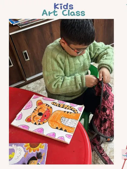 A young artist carefully packing away his tiger canvas painting. It's wonderful to see them take pride in their work.
