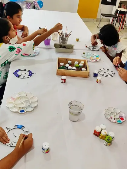 Another view of the Diwali-themed art party, with kids focused on adding color to their decorative hangings.