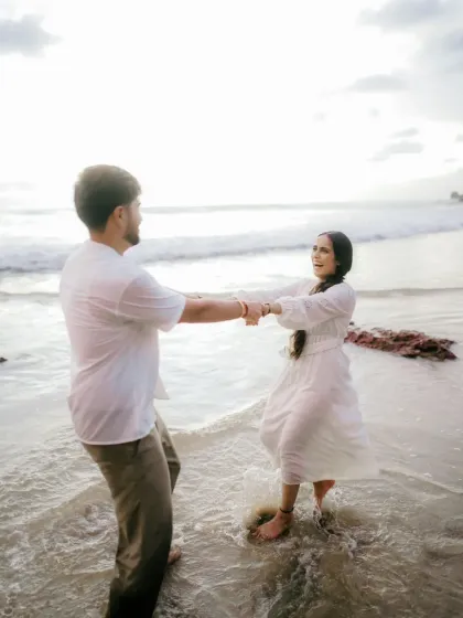 A candid shot of the couple dancing in the surf, their movements natural and joyful. This image captures the fun and playful side of their relationship during their Goa pre wedding session.
