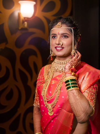 A radiant bridal portrait, capturing her happy smile and the complete look of her reception jewelry and saree.