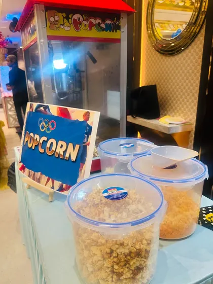 A close-up of our popcorn station, showing the machine full of fresh popcorn and containers with different flavor seasonings like cheese and caramel.