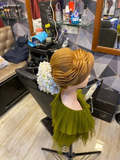 An elegant, layered updo with a large floral accessory, created during a masterclass. This style involves advanced layering and pinning techniques.