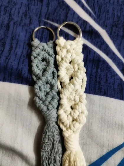Our macrame keychains are available in lovely pastel colors like this dusty blue and cream. The knotted design gives them a great texture and a bohemian feel.