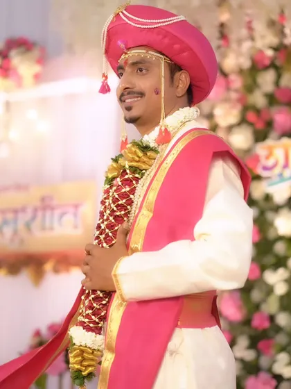 A side profile of the groom, showing the details of his traditional wedding attire.
