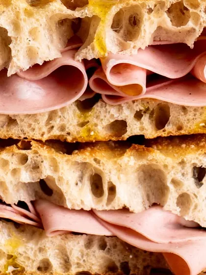 Another macro shot, this time of a mortadella sandwich. The focus is on the delicate folds of the meat and the texture of the bread.