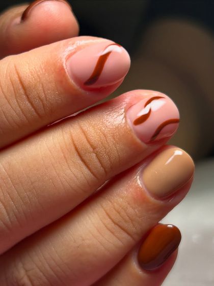 A close-up of these earthy brown swirl nails. The line work is so simple yet so effective.