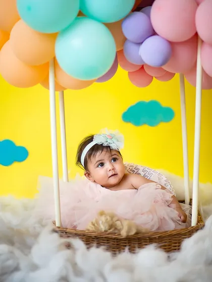 Peeking out from her pastel hot air balloon. This whimsical setup is perfect for a sitter session, creating the illusion that your baby is floating on a cloud.