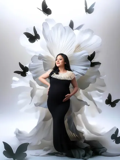 Another angle of our popular giant flower and butterfly set, this time with a lighter background, creating a high-contrast, artistic maternity portrait.