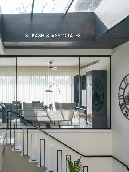 A large skylight and glass partitions flood this upper-level landing with natural light, creating a bright, inviting atmosphere and enhancing the sense of vertical space.