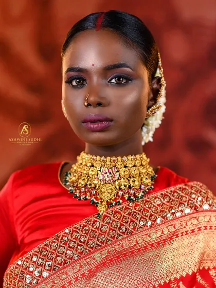 This shot captures the complete elegance of a South Indian bride. The composition balances the model's confident gaze with the ornate details of her attire, from the gold choker to the fine embroidery on her saree.