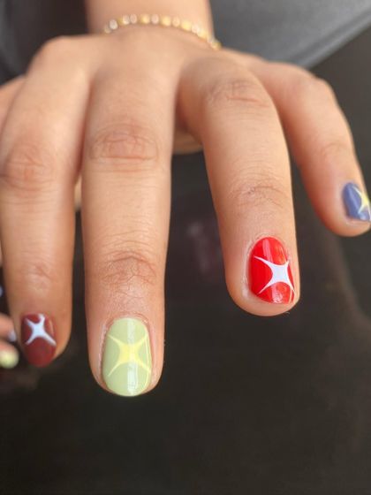 A close-up of the multi-color starburst nails. This design works great on short nails, proving you don't need length to have amazing nail art.