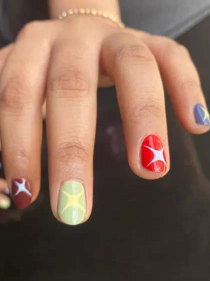 A close-up of the multi-color starburst nails. This design works great on short nails, proving you don't need length to have amazing nail art.
