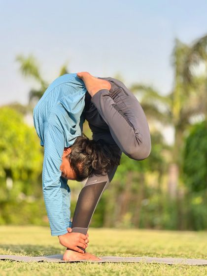 Another angle of the twisted forward bend, showing the depth of the stretch. The outdoor setting helps to calm the mind.