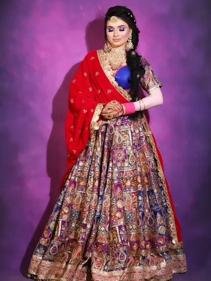 This multi-colored lehenga with a royal blue blouse is a stunning piece for any celebration. The heavy embroidery makes it look very rich and festive.