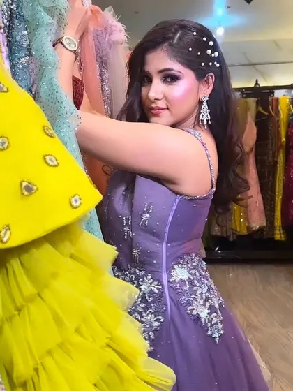 A client browsing through my collection of colorful gowns while wearing a beautiful lavender rental dress.