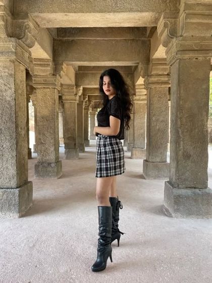 Exploring Hauz Khas Village in a dark academia-inspired outfit. I paired a black top with a plaid mini skirt and knee-high black boots for a look that's both stylish and perfect for walking around the city.