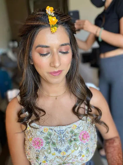 A soft and pretty look for a Haldi or Mehendi function. The makeup is minimal and fresh, with a simple floral maang tikka adding a festive touch.