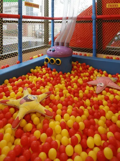 A view of our ball pit, filled with thousands of red and yellow balls. This area is constantly cleaned and maintained for safe play.