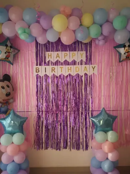 A pastel balloon theme for a 3rd birthday, featuring a Mickey Mouse foil balloon. The soft, multi-colored balloons create a gentle and cheerful atmosphere.