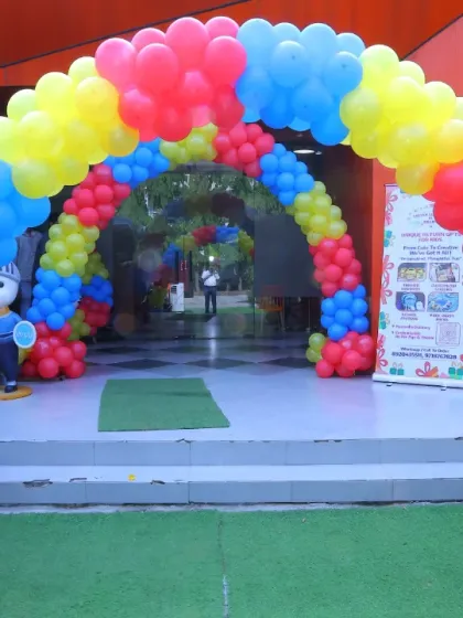 A vibrant, primary-colored balloon arch at the entrance of Wobble World, ready for a fun and festive birthday celebration.