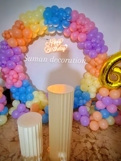 Another angle of the rainbow birthday setup, highlighting the texture and colors of the balloon garland.