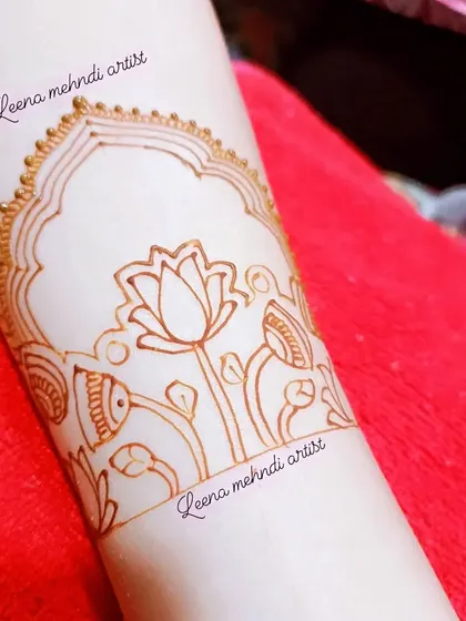 The outline for a floral cuff design, featuring a central lotus inside an arched frame. This is a great practice drill for symmetry and fine lines.
