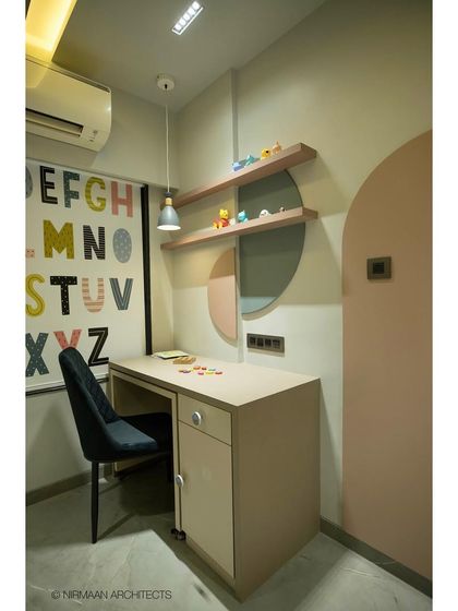 The study area in this toddler's room is both fun and educational, with a large alphabet poster on the wall. The design is clean and simple, allowing the colorful elements to stand out.