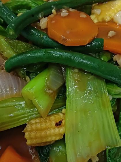 A finished stir-fry dish, showing how my unique vegetables can be used. This dish includes baby corn, beans, and other greens, all cooked to perfection.