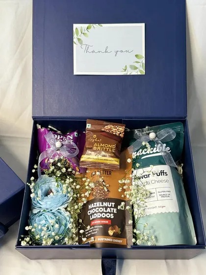 A detailed view of our blue corporate gift box. The arrangement includes flowers and carefully selected products to create a premium and thoughtful gift for any client or employee.