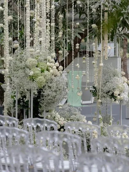 A view of the all-white wedding ceremony, with transparent chairs creating a modern and airy feel.