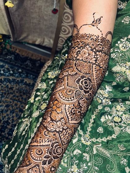 A close-up of the forearm, showing the intricate mix of floral, paisley, and geometric patterns.