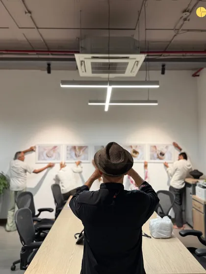 A behind-the-scenes look at the art installation process. Our principal architect oversees the placement of a series of photographs, ensuring the composition is balanced and impactful.