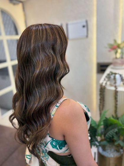Side view of a global colour and highlights service. The warm tones are perfectly blended for a natural yet impactful result.