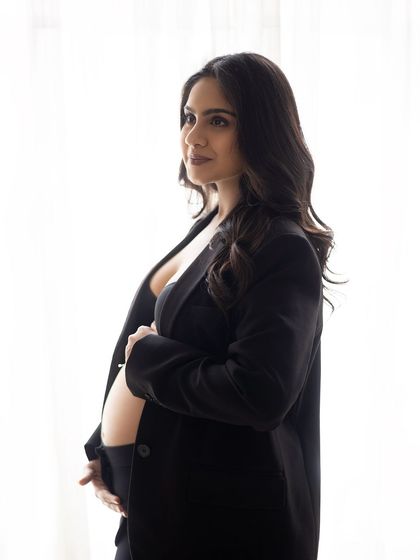 A modern and chic look. This portrait captures the mother-to-be in a black blazer, a stylish and confident take on maternity wear, shot with soft, natural light.